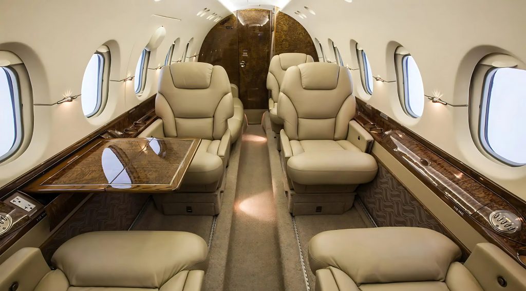 Interior de jet privado Hawker 800XP con acabados de lujo y configuración ejecutiva